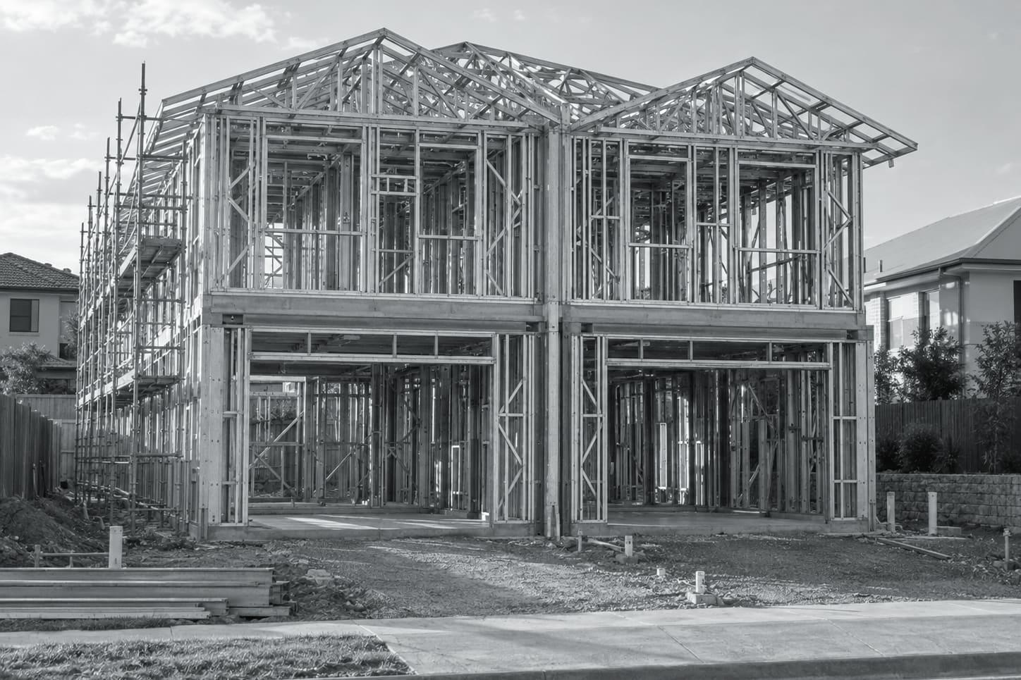 Illustrative image: steel wall frames for a pair of attached duplex dwellings on one slab