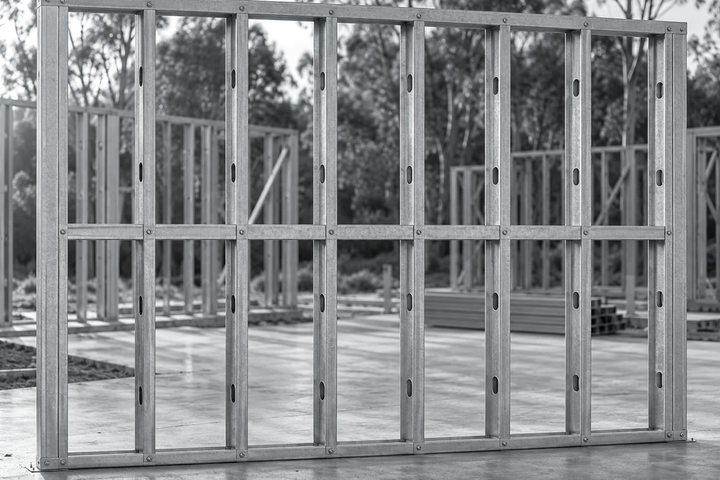 Illustrative image: galvanised light gauge steel wall panels with studs, noggings and a window opening standing on a slab