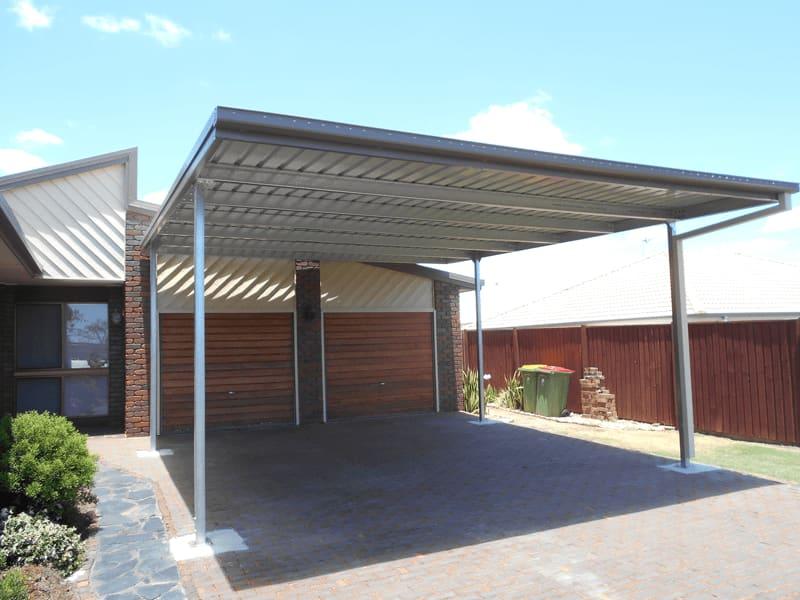 Skillion carport beside a brick house over a paved driveway