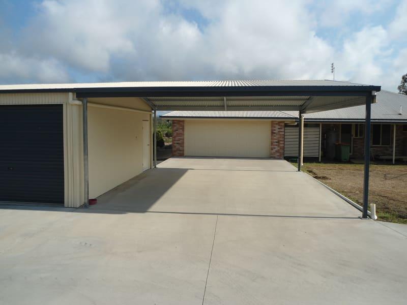 Cream double carport built beside a garage at a brick home