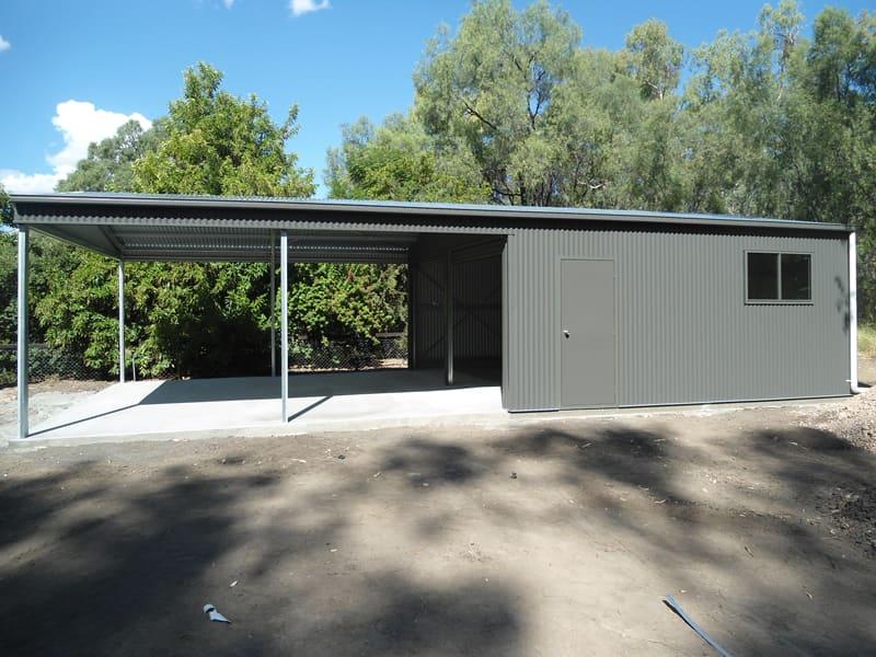 Grey shed with a long skillion awning among trees